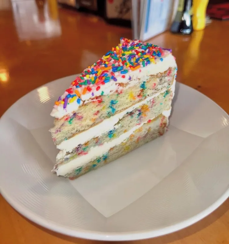 Slice of rainbow sprinkle cake at JD's Burger Co. & Sushi